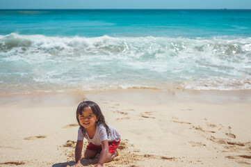 A little girl playing sand at the beach