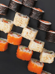 Japanese rolls on black stone background.