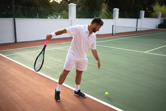 Caucasian man training on a tennis court
