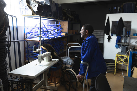 Disabled African American worker inspecting parts - Powered by Adobe