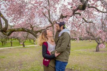 Fototapeta premium Happy couple laughing with beautiful flowers on the background