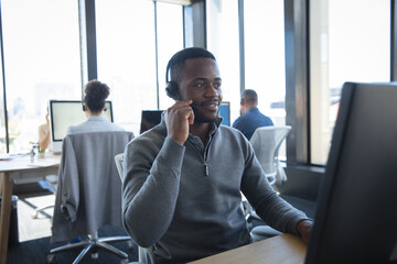 African American business man wearing a headset phone in office