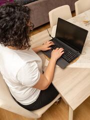 Fototapeta premium Concentrated young beautiful businesswoman working on laptop at home office. top right angle.