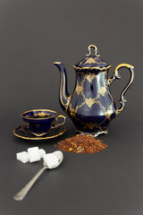 Still life with a beautiful cobalt blue colored vintage porcelain tea set with golden floral...