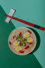 White plate with ramen and eggs in a green background in pop art style.