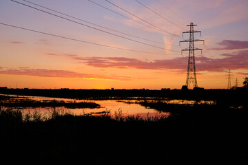 Silhouette electric high power pylon and wires at red sunset. 2020 the Netherlands