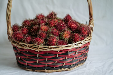 Fototapeta na wymiar Red rambutans in a red basket 