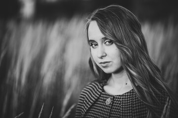 Portrait of a beautiful girl in autumn against the background of the field on the nature..Black and white photo.