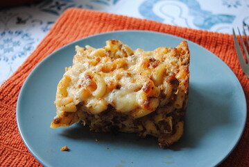 Baked Pasta with minced meat and cheese on a gray plate. Closeup view. 
