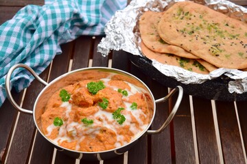 Murgh Makhani or butter chicken served with homemade whole wheat garlic Naan bread