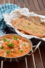 Murgh Makhani or butter chicken served with homemade whole wheat garlic Naan bread