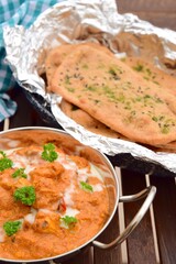 Murgh Makhani or butter chicken served with homemade whole wheat garlic Naan bread