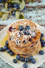 Gluten free buckwheat banana blueberry coconut pancakes with maple syrup