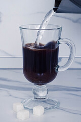 stock image of pouring hot drink to the mug