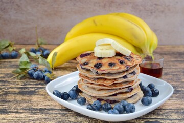 Gluten free buckwheat banana blueberry pancakes with maple syrup