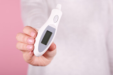 Electronic thermometer in hands.