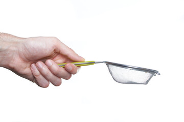 man hand holding strainer utensil. Kitchen concept.