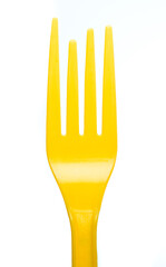Yellow plastic fork isolated on white background. Children education in the kitchen.