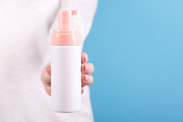 Face foam bottle in hand.