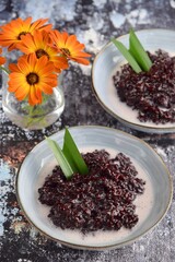 Obraz na płótnie Canvas Bubur Ketan Hitam, Indonesian dessert. Black glutinous rice porridge with coconut milk, palm sugar and pandan leaf.