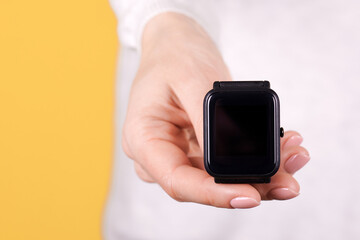 Black smart watch in hand.