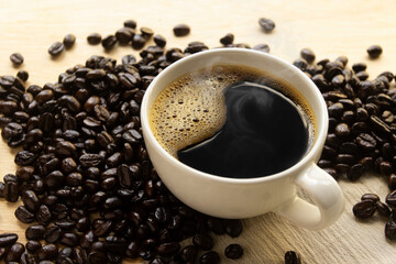 Hot Black coffee with smoke and coffee beans on wooden