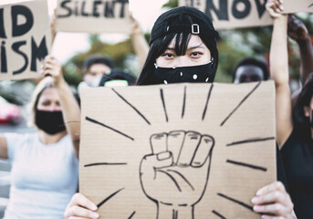 Asian girl wearing face mask while protest against racism on city street - Equal rights for people...