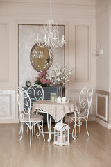 Beautiful classic interior with spring mood. Elegant metal chairs. Room in beige colors