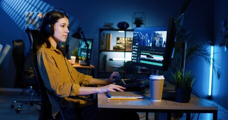Picture of professional female video editor editing video on his personal computer with two displays in modern video studio. - obrazy, fototapety, plakaty