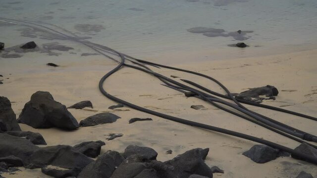 Long black pipes going into salt water of the sea, desalination system, Fiji