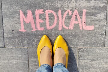 Medical concept, top view on woman legs and text written in chalk on gray sidewalk