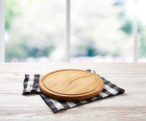 Empty pizza board and table cloth on wooden deck table with napkin. Kitchen background.