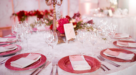 served table with plates ant glasses decorated by flowers