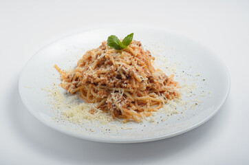 Spaghetti Bolognese is an Italian dish,a type of pasta serving with meat sauce used for such a serving. Beautiful serving with grated cheese and herbs. For sites with food delivery and for menu design