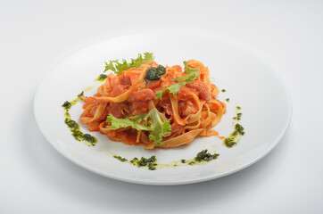 Tagliatelle Amatricana. It’s a hearty, tasty, and healthy dish made from natural ingredients: bacon, parmesan cheese, pesto sauce, tomato sauce, onion. In a beautiful feed on a white background