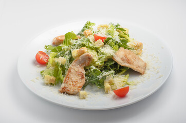 Caesar salad with turkey. Beautiful serve on a white plate. filmed on a white background for use in online food delivery catalogs and restaurant menus