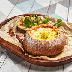 Cheese soup served in round bread loaf