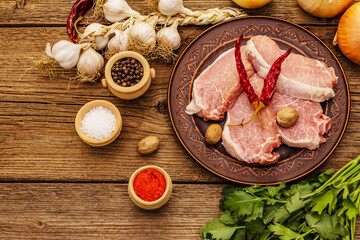 Raw pork meat. Fresh loin, spices, fragrant vegetables and parsley