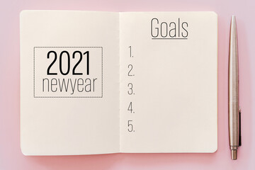 2021 new year goals on notebook with pencil.