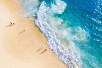 Beach, people and waves. Coast as a background from top view. Blue water background from drone....