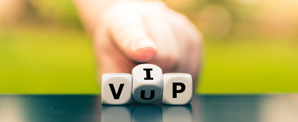 Hand turns dice and changes the acronym "VUP" (very unimportant person) to "VIP" (very important person).