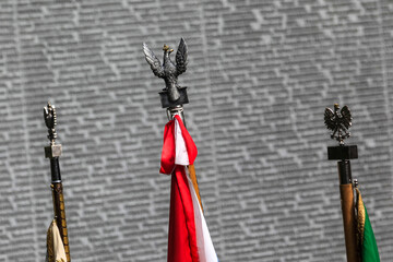 State flags of Poland near Memorial wall with the names of Poles, at the Polish cemetery in Bykivnia, Kyiv. Ukraine.