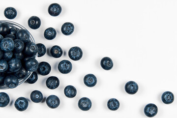 Freshly juicy picked blueberries in glass bowl isolated on white background. 