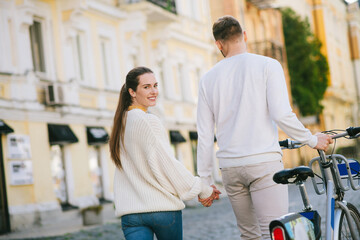 Man with bicycle from the back and woman looking back