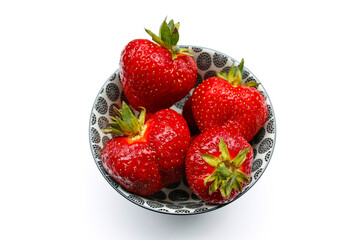 Juicy strawberries in a bowl on a white background