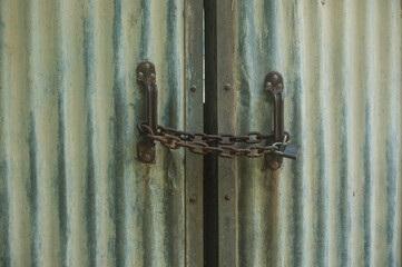 Old corrugated doors closed with chain and lock