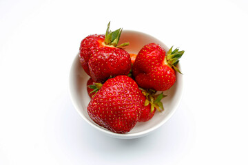 Juicy strawberries in a bowl on a white background