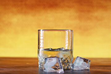 A glass of hard alcohol with ice on a bar counter. Whiskey with soda in a glass. Advertising alcoholic drink.