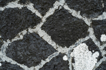 Black basalt rock wall background with white cement joints