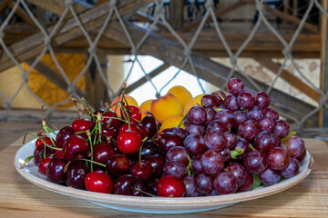 Plate with fruits on a wooden table. Fresh fruits on a plate. Fruit still life. Dish of fresh fruit.